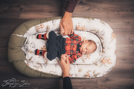Baby in einer Babyschale und beiden Händen der Eltern - Familienfotograf Brüggen Stephan Sohn
